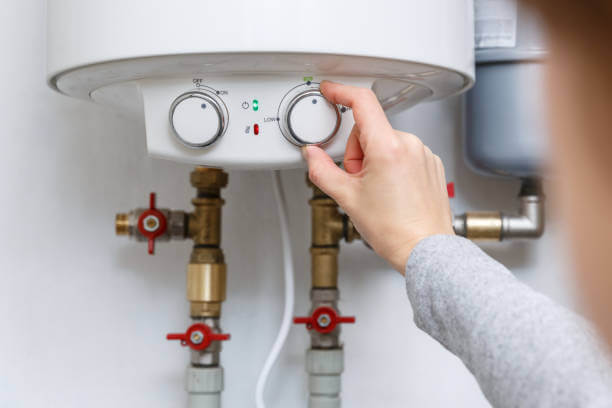 A homeowner adjusts the settings on a boiler.