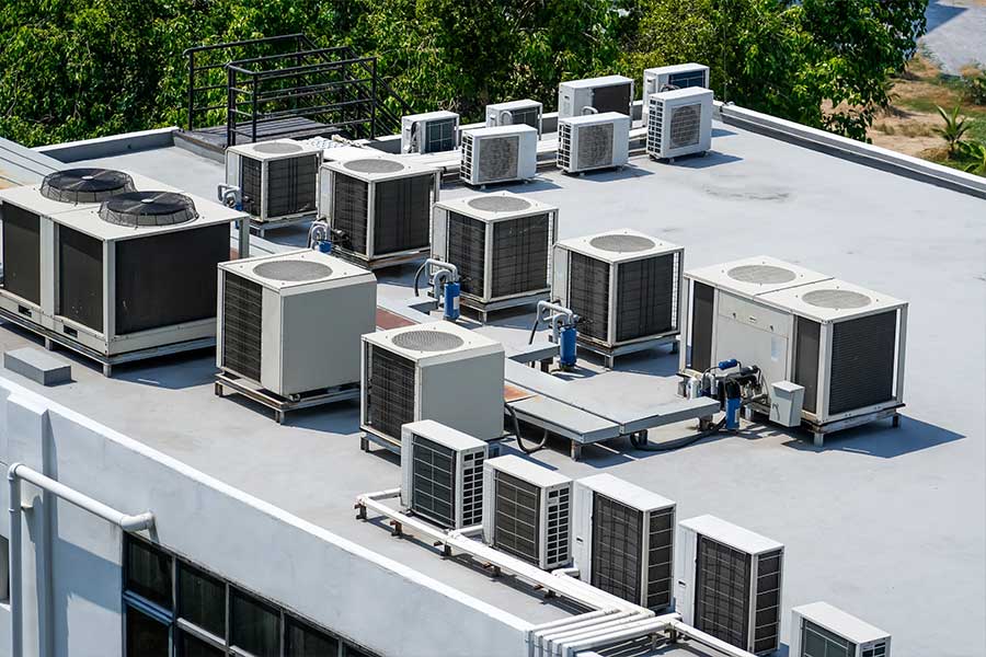 Rooftop commercial HVAC equipment arranged across a flat building roof