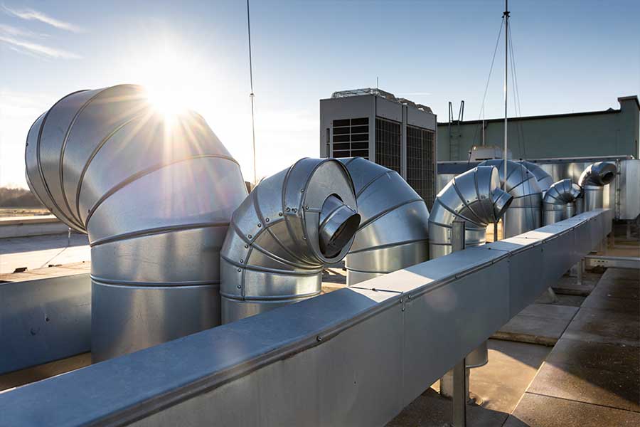Rooftop commercial HVAC system with large metal ducts during repair service